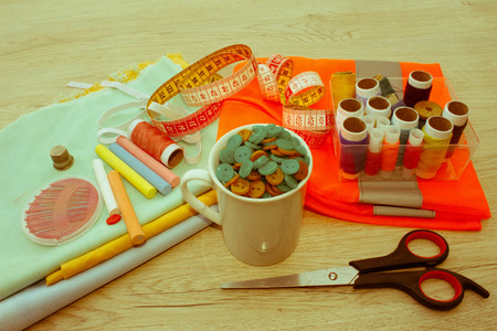 Sewing still life: colorful cloth. Sewing kit includes threads of different colors, thimble and...
