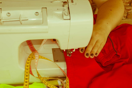 designer making a garment in her workplace. seamstress sews clothes. Workplace of tailor - sewing...