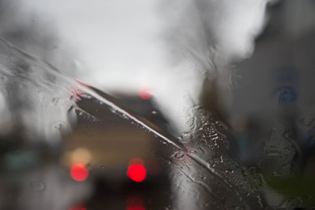 Rainy days,Rain drops on window,rainy weather,rain background,rain and bokeh. Blurry bus silhouette