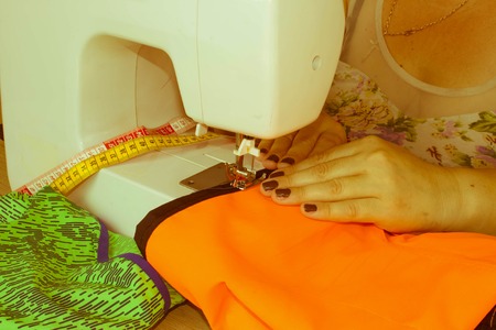 Woman hand on sewing machine.Dressmaker work on the sewing machine. Hobby sewing fabric as a small...
