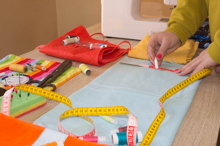 Female fashion designer working at studio with pattern cuttings and sketches. Garment industry,...