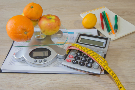 Healthy natural organic food diet, ripe harvest. Fruit composition, measuring tape, calculator with diet plan. Concept diet and weight loss on the tableの写真素材