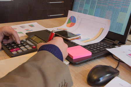 Businessman using a calculator to calculate the numbers. Businessman calculate finance and thinking...