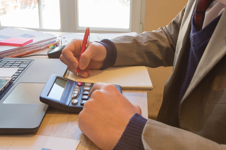 Businessman using a calculator to calculate the numbers. Businessman calculate finance and thinking...