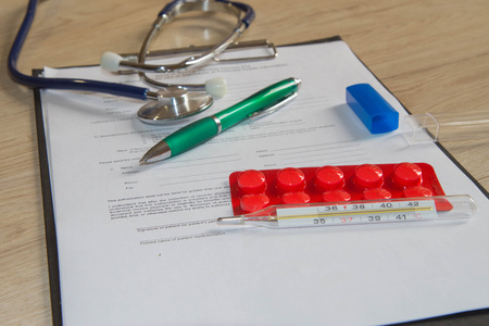 blank paper on clipboard with pen. Designer's blank. Stethoscope in doctors desk