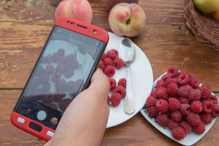 Woman hands takes photography of food on table with phone. Smartphone photo for social networks post. Vegetarian, healthy, organicの写真素材
