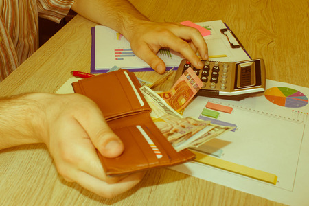 Man, Calculator and money thai banknote on wooden table. The concept of financial planning, savings....