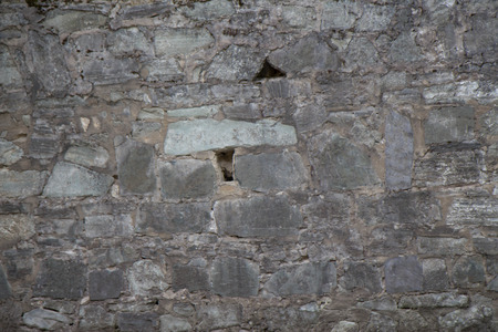 Stone wall as a background or texture. An example of masonry as a cladding of external walls. part of a stone wall, for background or texturの写真素材
