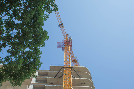 A crane in a construction work. Empty copy space for Editor's text. Modern civil engineering