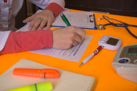 Doctor working at table in office. doctor concept in hospital. Hands of a doctor filling RX...