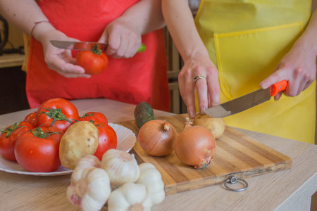 Woman hands cutting vegetables in the kitchen. Preparing dishes. Woman in kitchen preparing vegetables. Healthy Foodの写真素材