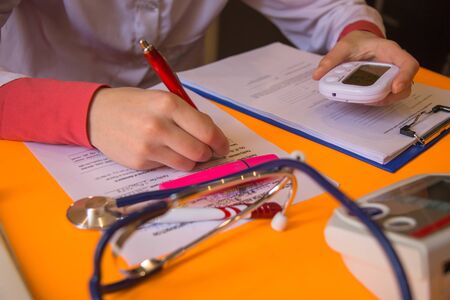 Close up of male doctor filling patient document pen on white desk in hospital. doctor concept in hotpitalの写真素材