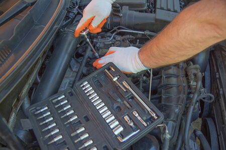 car service, repair, maintenance and people concept - auto mechanic man with wrench working at...