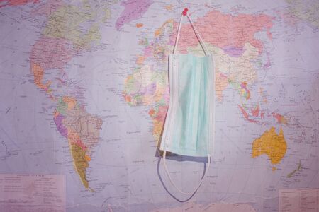 Virus illness. Coronavirus medical mask on map background. Surgical protective maskの写真素材