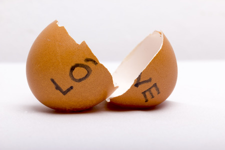 "LOVE" written at broken eggs with white backgroundの写真素材