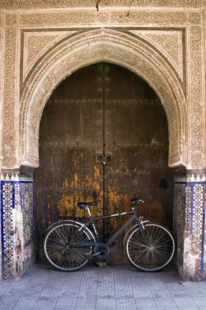 Bicycle leaning aginst a door under an archway in Marrakechの写真素材