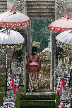 Balinese woman entering a templeのeditorial素材
