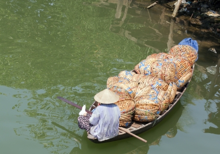 Woman in boat full of baskets, Hoi An, Vietnamの写真素材