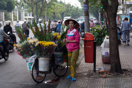HO CHI MINH CITY,VIETNAM-NOV 5TH: A flower seller on November 5th 2013. Many street vendors can be found selling their wares in Ho Chi Minh.のeditorial素材