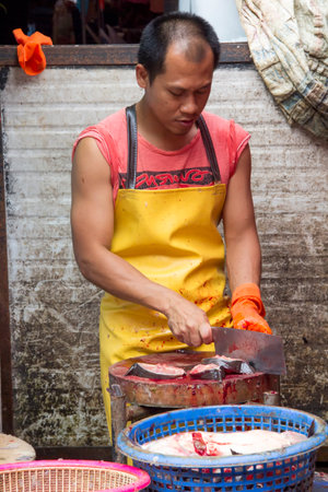 Bangkok, Thailand-June 24th 2013: A fishmonger preparing fish for sale at Khlong Toei market. The market is the largest wet market in Bangkok.のeditorial素材