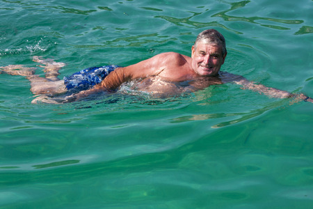 Senior man swimming in the sea at Koh Racha, Phuket, Thailandの写真素材