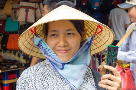 Ho Chi Minh City, Vietnam-29th Oct 2013: Woman street vendor selling fans. Street vendors can be found all over the city.のeditorial素材