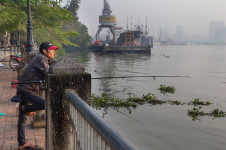 Ho Chi Minh City, Vietnam-29th Oct 2013: Man fishing in the Saigon river. Th river rises in Cambodia and flows for 230 kms before empting into the Nha Be river.のeditorial素材