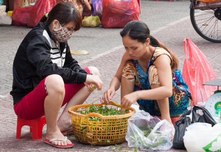 Ho Chi Minh City, Vietnam-Nov 1st 2013: Street vendorssorting vendors. Vendors can be found everywhere in the city.のeditorial素材