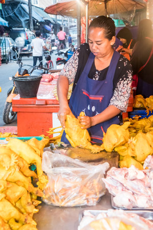 Mae Sot, Thailand - February 3rd 2019: Woman preparing chicken for sale on the market. The market is open every day.のeditorial素材