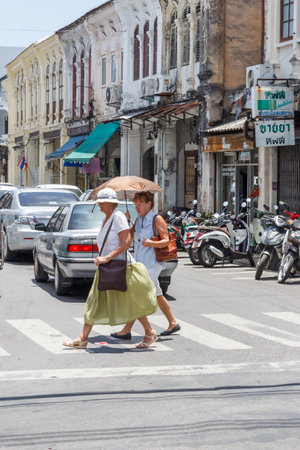 Phuket, Thailand - August 17th 2013: Two senior women crossing Thalang Road in old Phuket Town, The architecture is typical sino portuguese style.のeditorial素材