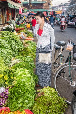 Mae Sot, Thailand -  3rd February 2019: Burmese girl shops for vegetables on the market. There are many Burmese in the town.のeditorial素材
