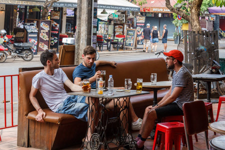 Siem Reap, Cambodia - 9th January 2019: Young men drinking in a bar in Pub Street, There are many bars catering to tourists.のeditorial素材