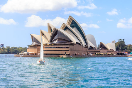 Sydney, Australia - January 4th2014: A yacht sails past the Opera House in the harbour. The building is an iconic piece of architecture.のeditorial素材