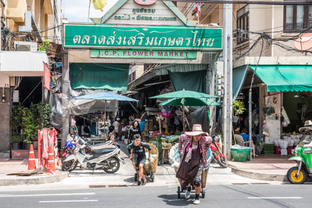 Bangkok, Thailand - 26th September 2018: Porters crossing the road outside the ICP flower market. This is the largest flower market in the city.のeditorial素材