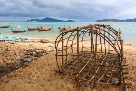 Fish trap and boats under a stormy looking sky, Rawai, Phuket, Thailandの写真素材