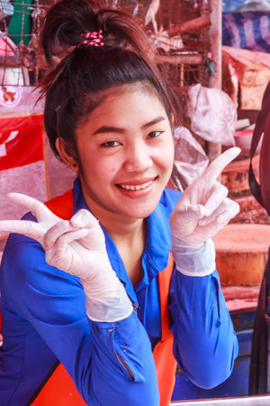 Bangkok, Thailand - November 14th 2015: Smiling girl vendor on Khlong Toei market. This is the city's largest wet market.のeditorial素材