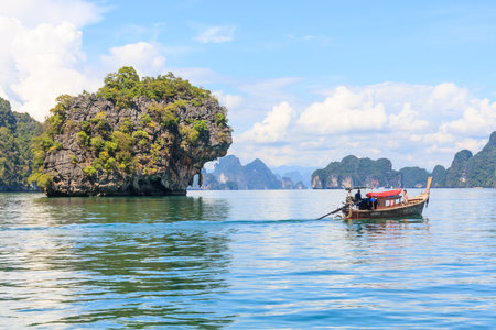Phuket, Thailand - January 18th 2012: Tourists in a long tail boat in Phang Nga Bay. The area is known for the limestone karsts and islands.のeditorial素材