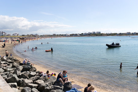 Anglesey, Wales - August 17th 2015: People enjoying the sunshine in Trearrdur Bay. This is a popular beach on a sunny day.のeditorial素材