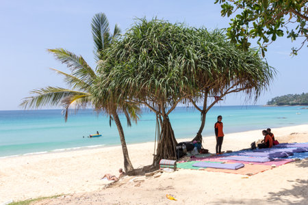 Phuket, Thailand - October 16th 2014: Massage girls sat under a tree waiting for business, Surin beach This is one of the most popular beaches on the islandのeditorial素材
