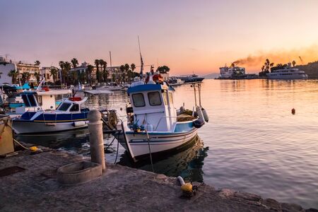Sunrise over the harbour with smoke from funnel of ferry ship, Kos, Greece