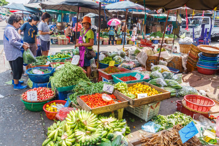 Bangkok, Thailand - January 5th 2010: Woman selling fruit and vegetables on Khlong Toei market. This is the largest wet market in the city.のeditorial素材