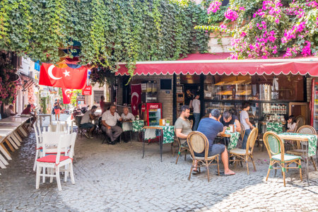 Alacati, Turkey - September 6th 2019: Tourists sitting in a cafe. Many tourists visit the town.のeditorial素材