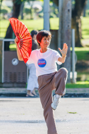 Bangkok, Thailand - 20th September 2009: Woman exercising with fan in Lumphini Park. The park is known as Bangkok's green lung.のeditorial素材