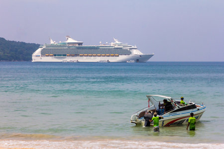 Patong, Phuket, Thailand - November 11th 2017: Speedboat with cruise ship Mariner of the Seas in the background. Patong is a popular cruise destination.のeditorial素材