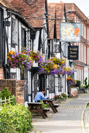 Amersham, England - August 22nd 2019: A man sits outside the Kings Arms Hotel in the old town. The hotel dates from the 15th century.のeditorial素材