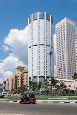 Colombo, Sri Lanka - March 16th 2011: A tuk tuk goes around a roundabout in the Fort district.  Modern skyscrapers are springing up all over the city.のeditorial素材