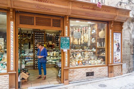 Toledo, Spain - 6th June 2018: A woman looks at wine in a local produce shop. The area has its own wines, cheese and sausage.の写真素材