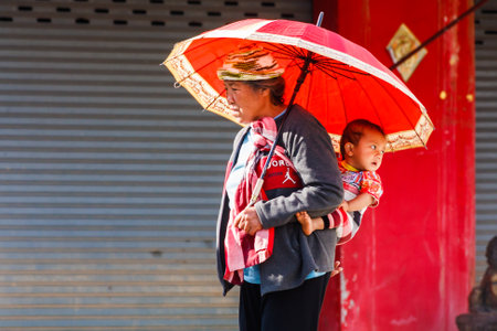 Mae Sai, Thailand - November 29th 2011: Ethnic burmese woman and child crossing the border. This is a busy border crossing.のeditorial素材