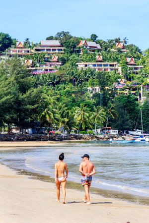 Phuket, Thailand - 7th March 2018 - Couple walking along tropical beach, Bang Tao. The area is a popular holiday destinationのeditorial素材