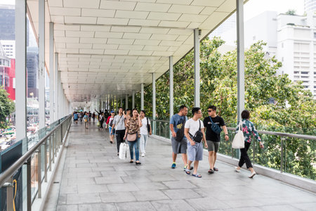 Bangkok, Thailand - October 23rd 2019: People walking along a skywalk. It connects the PLatinum Mall...